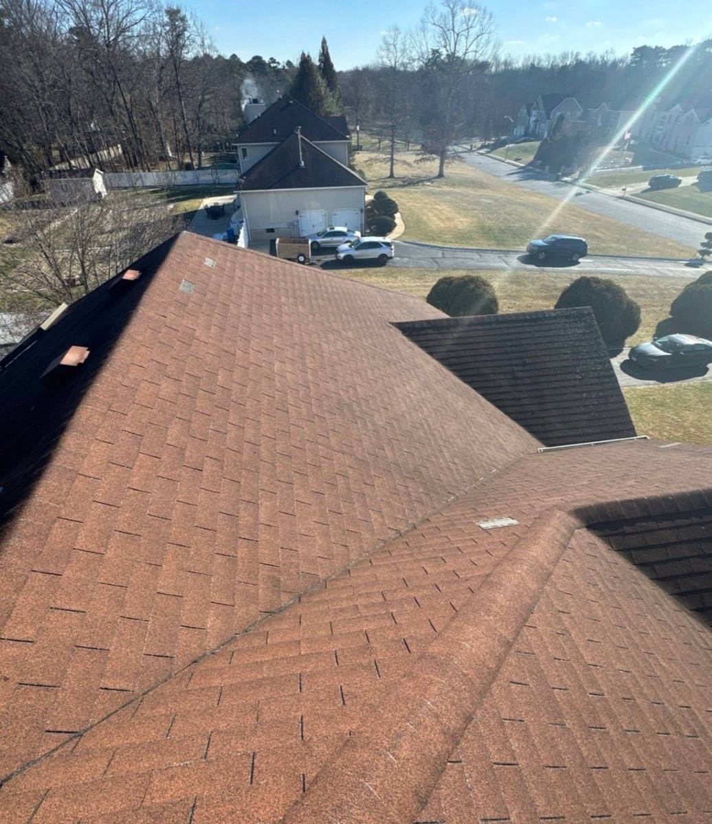 Older brown shingles on a residential roof before replacement